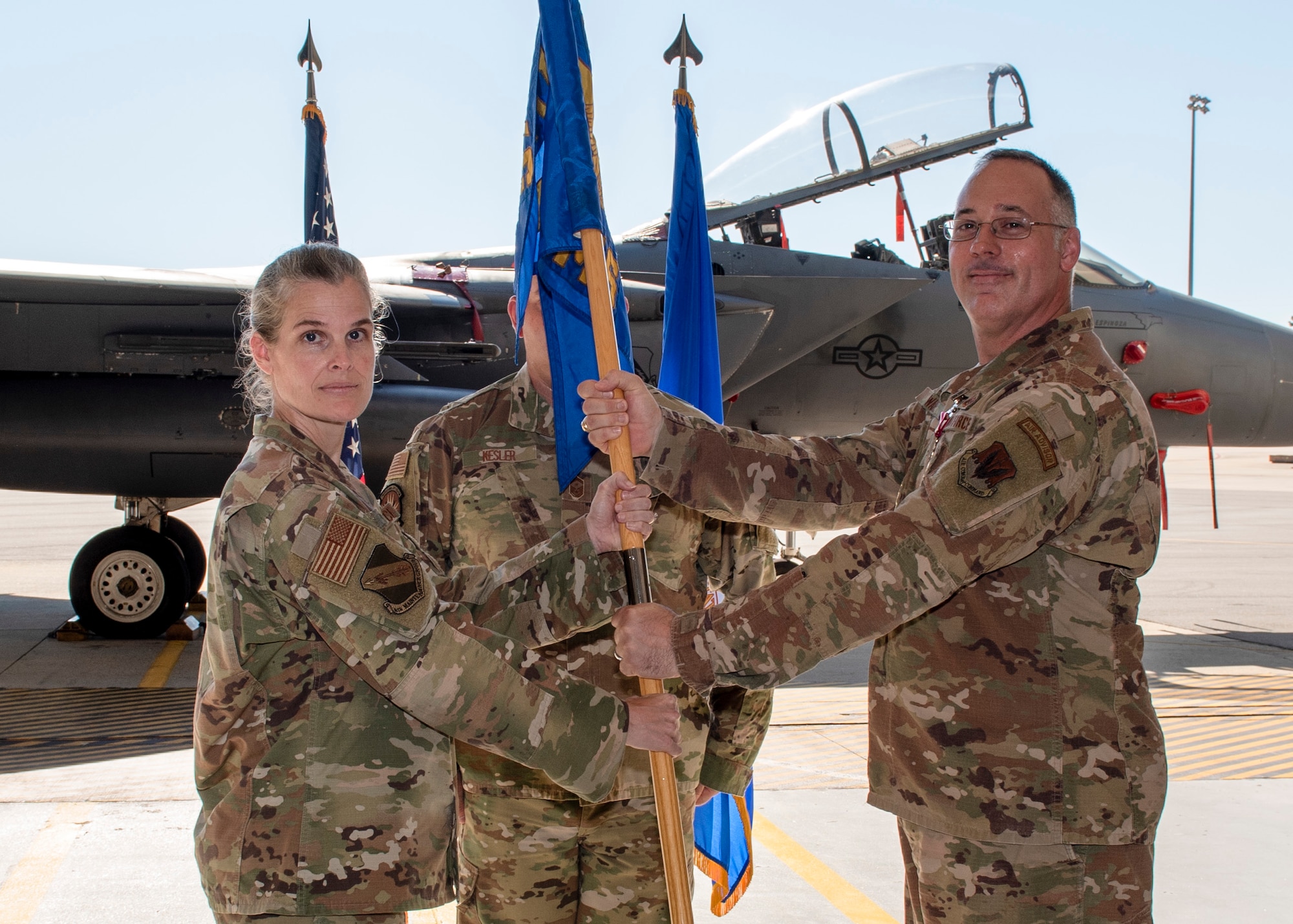 Maj. John R. Ware, 4th Equipment Maintenance Squadron commander (right), passes the guidon flag to Col. Leah R. Fry, 4th Maintenance Group commander (left),during a change of command ceremony at Seymour Johnson Air Force Base, North Carolina, June 26, 2020.