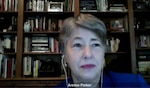 Woman wearing earbuds speaks during a virtual observation for Lesbian, Gay, Bisexual, Transgender and Queer month.