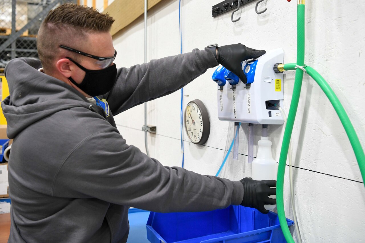 A contractor fills up spray bottles with cleaning disinfectant.