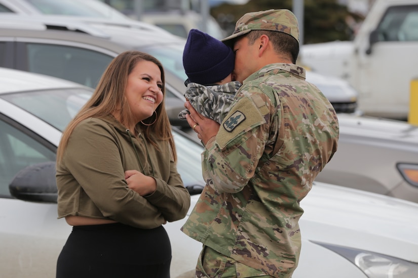 Sgt. Daniel Pau, a Soldier assigned to 1st Battalion, 297th Infantry Regiment, Alaska Army National Guard kisses his baby boy for the first time at Ted Steven Anchorage International Airport Apr. 4, 2020. Pau had just returned from a 9 month deployment to Kosovo for a NATO peacekeeping mission. (U.S. Army National Guard photo by Sgt. Seth LaCount/Released)