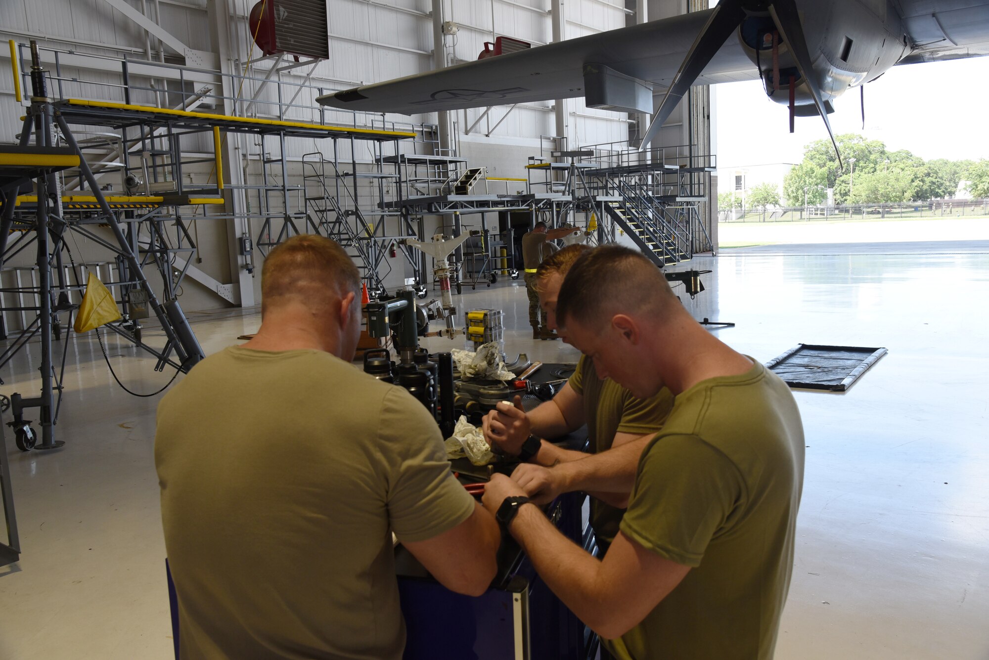 Tech Sgts. Cody McKay, Jason Priest and Senior Airman Ethan Ladnier, 403rd Maintenance Squadron aerorepair technicians, inspect and clean the parts to be installed on the new front strut on a WC-130J Super Hercules during a C letter inspection, which is the longest and most invasive inspection that occurs on the aircraft at Keesler Air Force Base, Mississippi. (U.S. Air Force photo by Jessica L. Kendziorek)