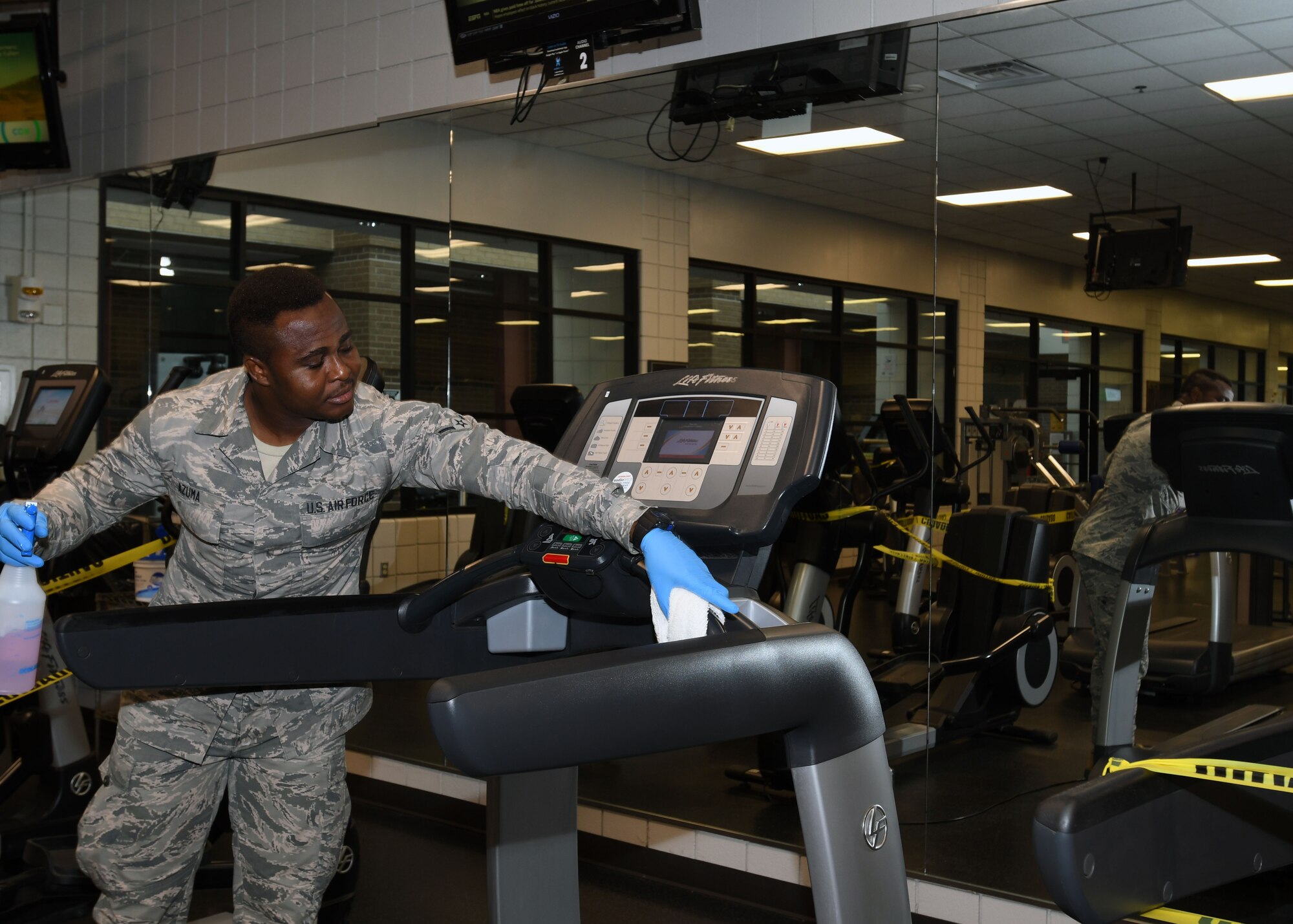 Airman Moise Azuma, 22nd Force Support Squadron fitness and sports apprentice, wipes down treadmills during the sanitation hour June 19, 2020, at McConnell Air Force Base, Kansas. The facility started these procedures when they reopened on May 19, 2020 and will continue as long as necessary. (U.S. Air Force photo by Tech. Sgt. Jennifer Stai)