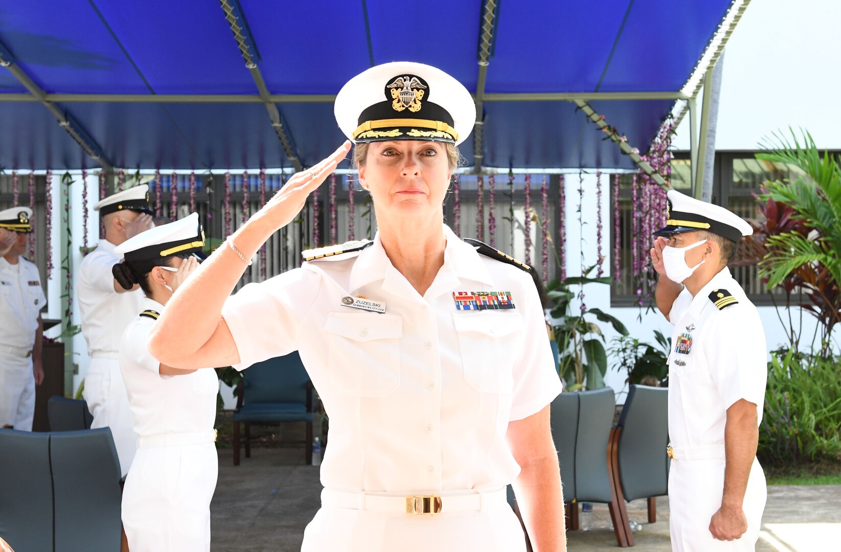 Outgoing Commanding Officer salutes as she is piped ashore.