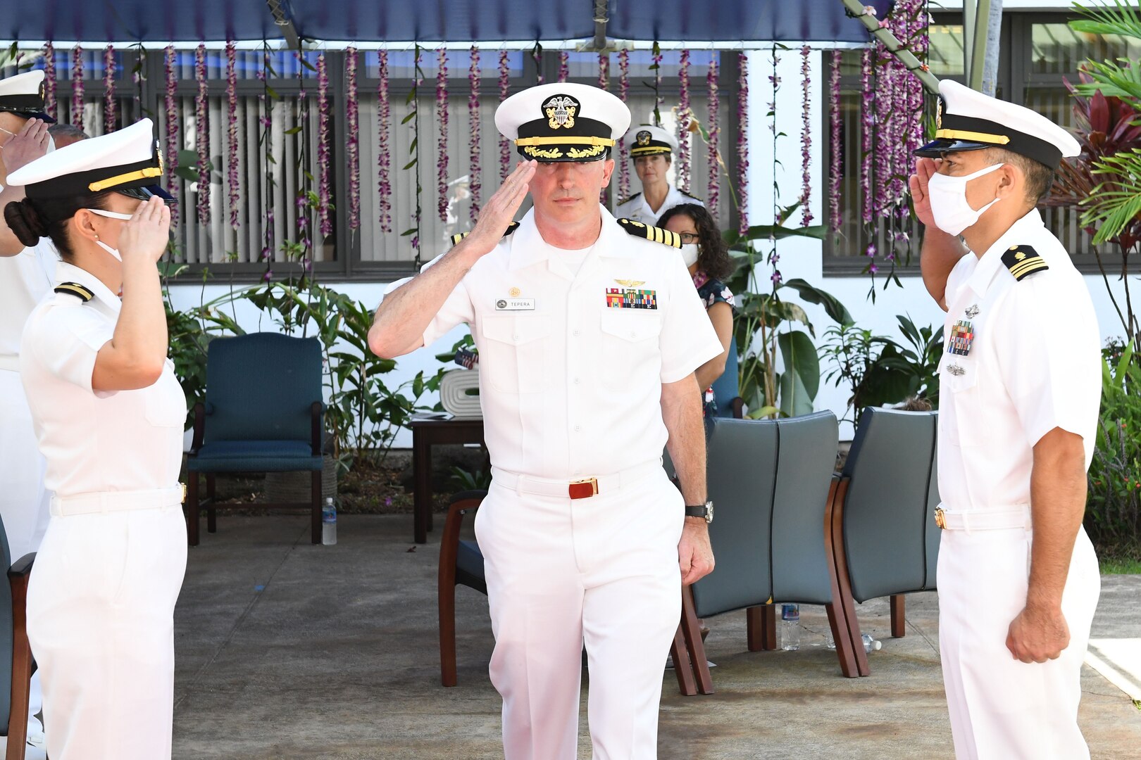 The Commanding Officer of Navy Medicine Readiness and Training Command Pearl Harbor salutes as he is piped ashore by the boatswain following the ceremony.