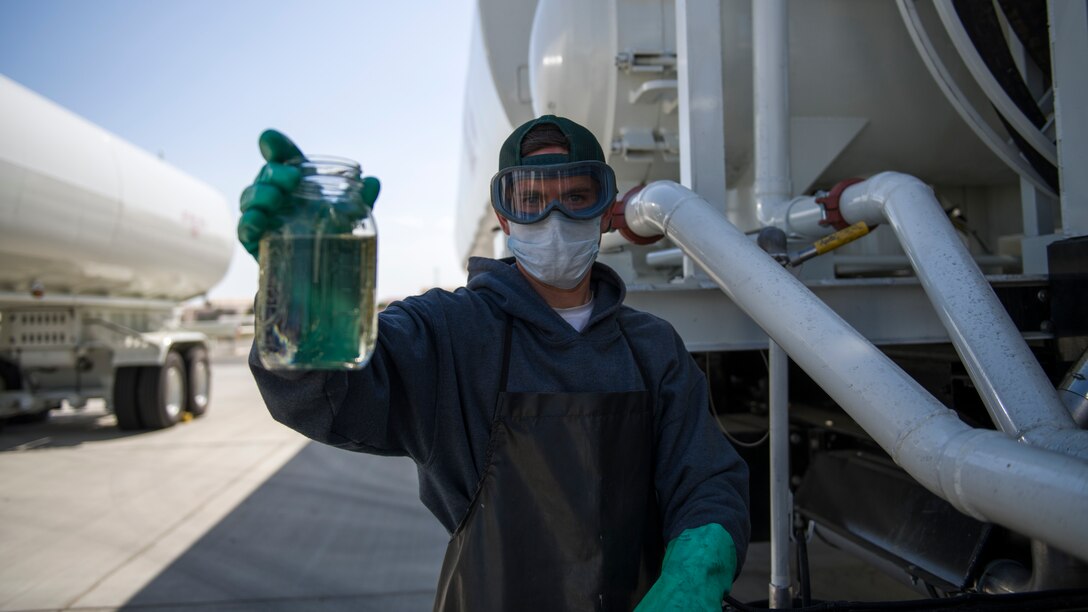Daniel Beasley, a Fuels Distribution Service Operator, 412th Logistics Readiness Squadron, holds up a jar of jet fuel during a filter system check of the Large Capacity Refuel Vehicle at Edwards Air Force Base, June 26. (Air Force photo by Giancarlo Casem)