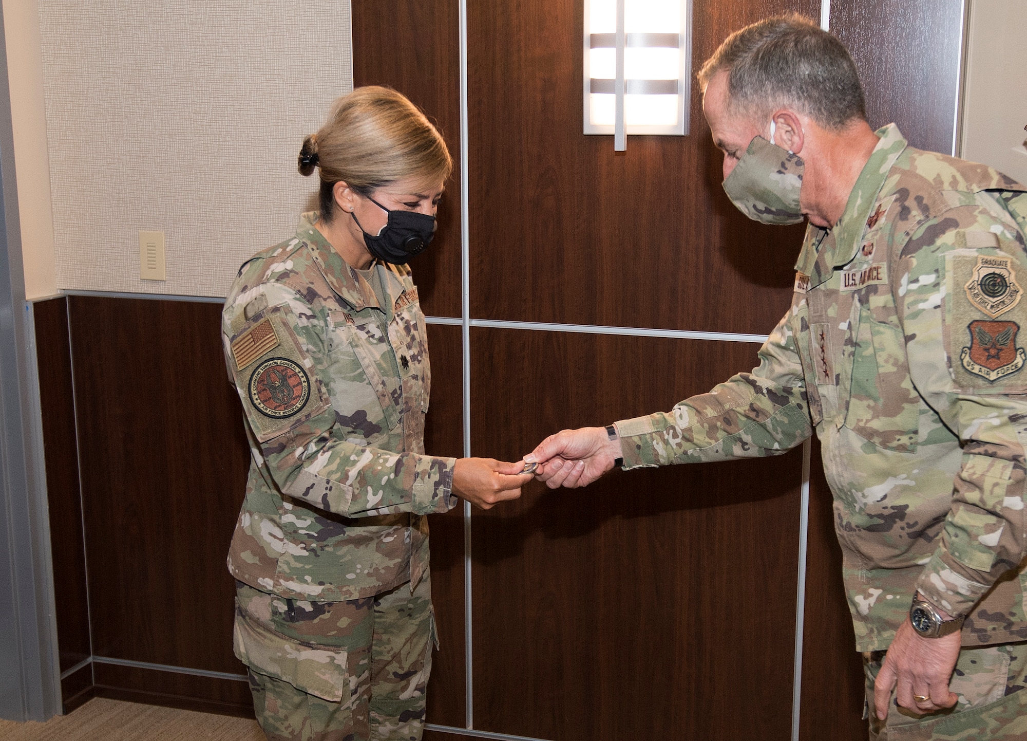 Photo of Air Force Chief of Staff Gen. David L. Goldfein, giving a coin to Air Force Reserve Command Public Health Officer Lt. Col. Jessica Dees for her contributions in the battle against COVID-19, at Robins Air Force Base, Georgia, June 24, 2020.