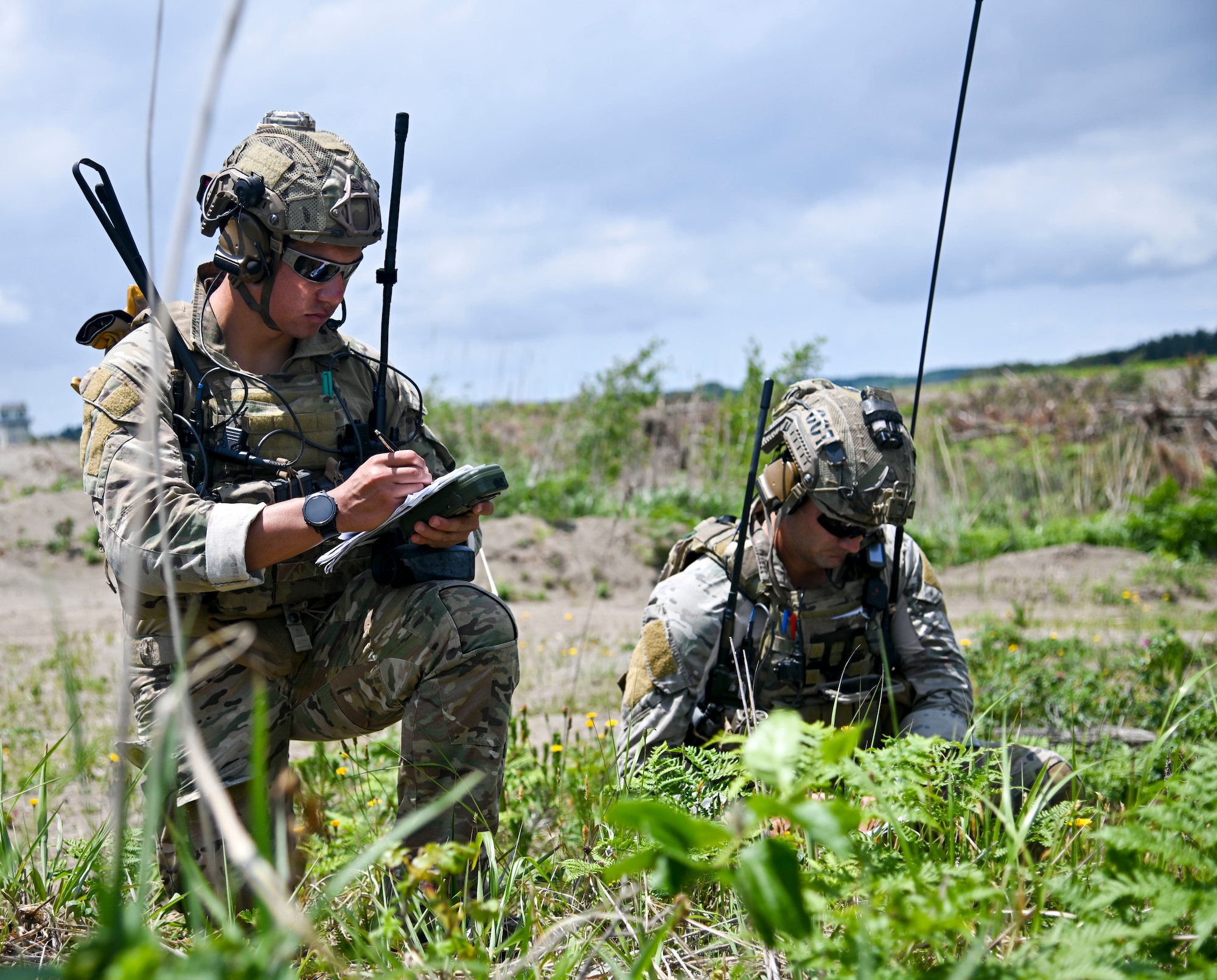 A U.S. Air Force joint terminal attack controller, left, fills in information for a 9-line while another JTAC, both assigned to the 320th Special Tactics Squadron, evaluates him at Draughon Range, near Misawa Air Base, Japan, June 15, 2020. A 9-line is a standardized format in which a JTAC gives targeting information to aircraft pilots. Brandt and other JTACS from the 320th STS came to Draughon Range to maintain their currency as combat controllers. (U.S. Air Force photo by Tech. Sgt. Timothy Moore)
