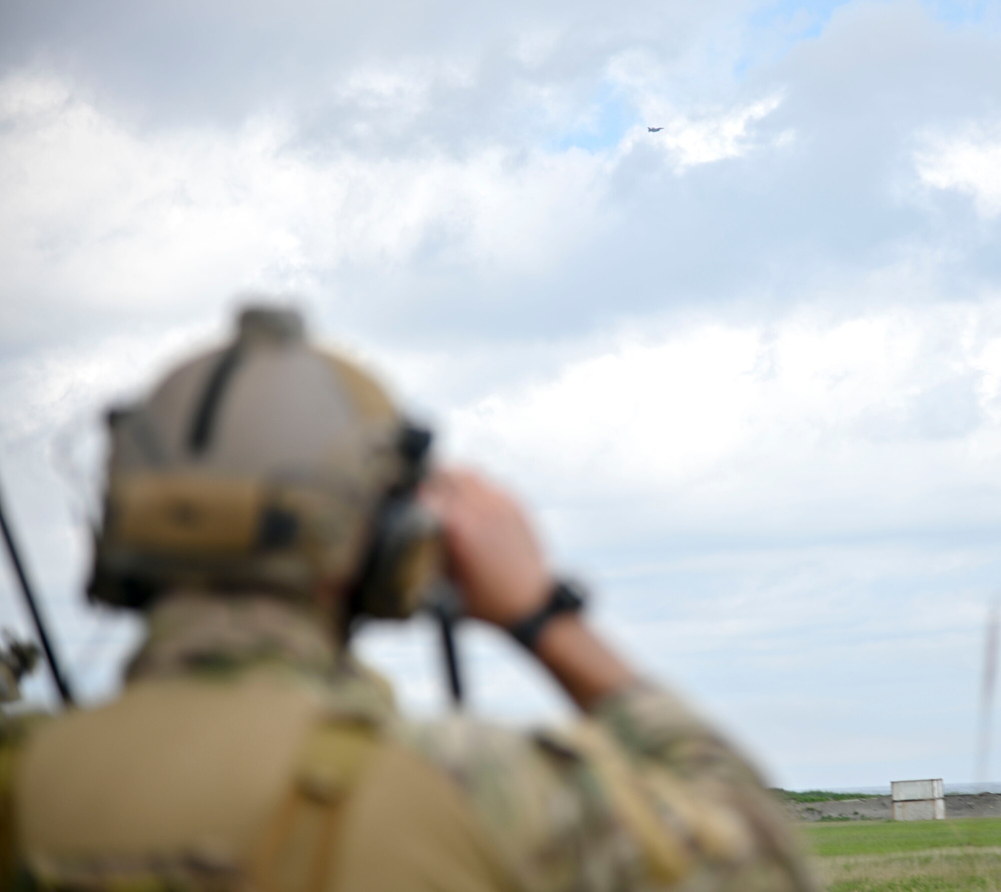 A U.S. Air Force joint terminal attack controller assigned to the 320th Special Tactics Squadron watches  an F-16 Fighting Falcon assigned to the 13th Fighter Squadron fly over a target at Draughon Range, near Misawa Air Base, Japan, June 15, 2020. The JTACs and the F-16 pilots teamed up to conduct close air support training to maintain their proficiency. Due to safety precautions taken in response to the coronavirus, many training opportunities have been postponed or cancelled. Fortunately, Misawa Air Base has Draughon Range to conduct some of the missed training and allowed the JTACs to come from Kadena Air Base to maintain their currency on fixed-wing CAS. (U.S. Air Force photo by Tech. Sgt. Timothy Moore)