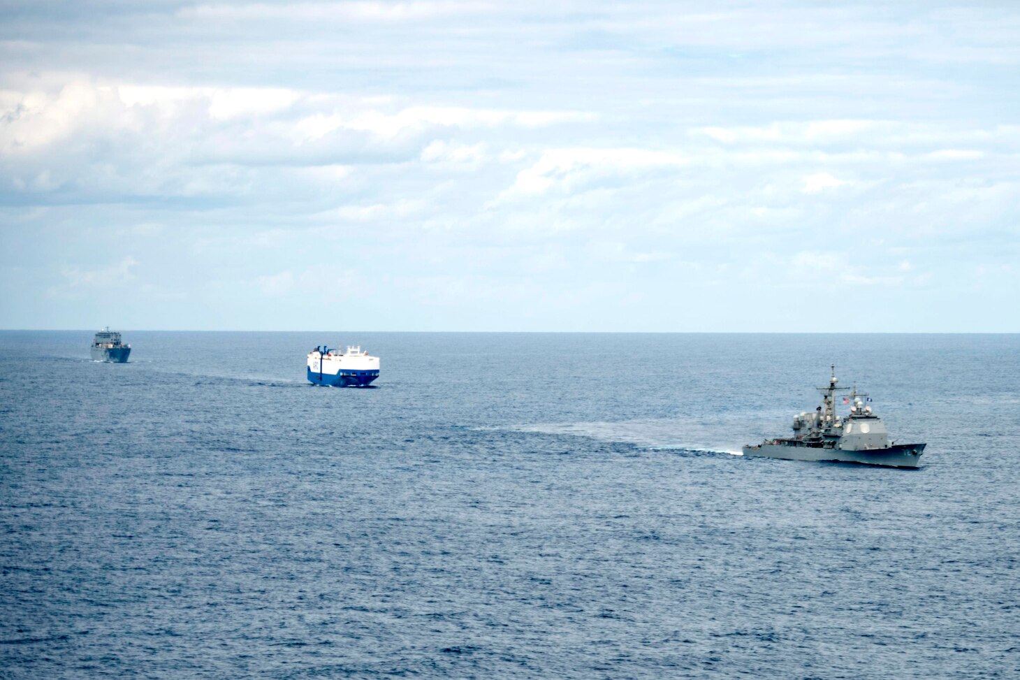 USS Vella Gulf (CG 72), right, the vehicle carrier MV Resolve, center, and the Military Sea Lift Command (MSC) roll-on roll-off cargo ship USNS Benavidez (T-AKR 306) steam in formation