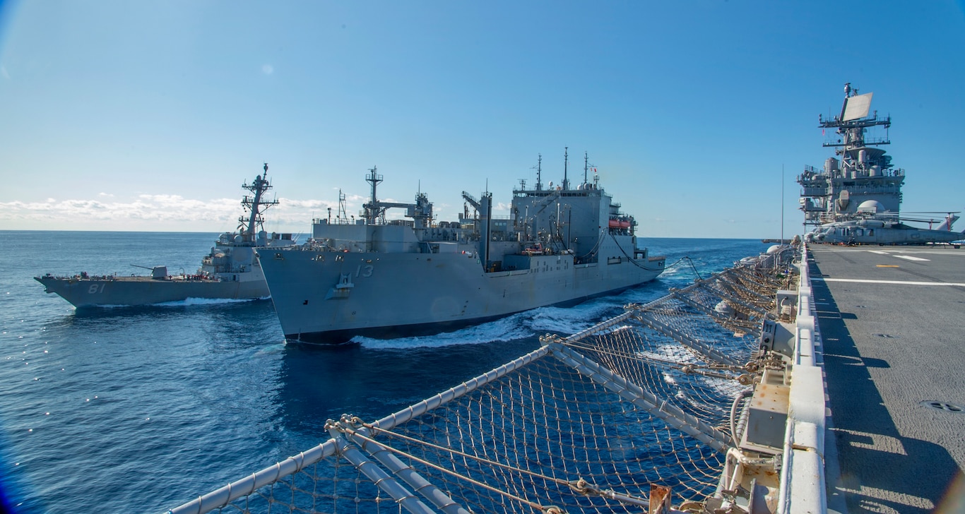 USNS Medgar Evers (T-AKE-13) refuels the Wasp-class amphibious assault ship USS Iwo Jima (LHD 7) to her port side and USS Winston S. Churchill (DDG 81) to her starboard side during a replenishment-at-sea, February 23, 2020