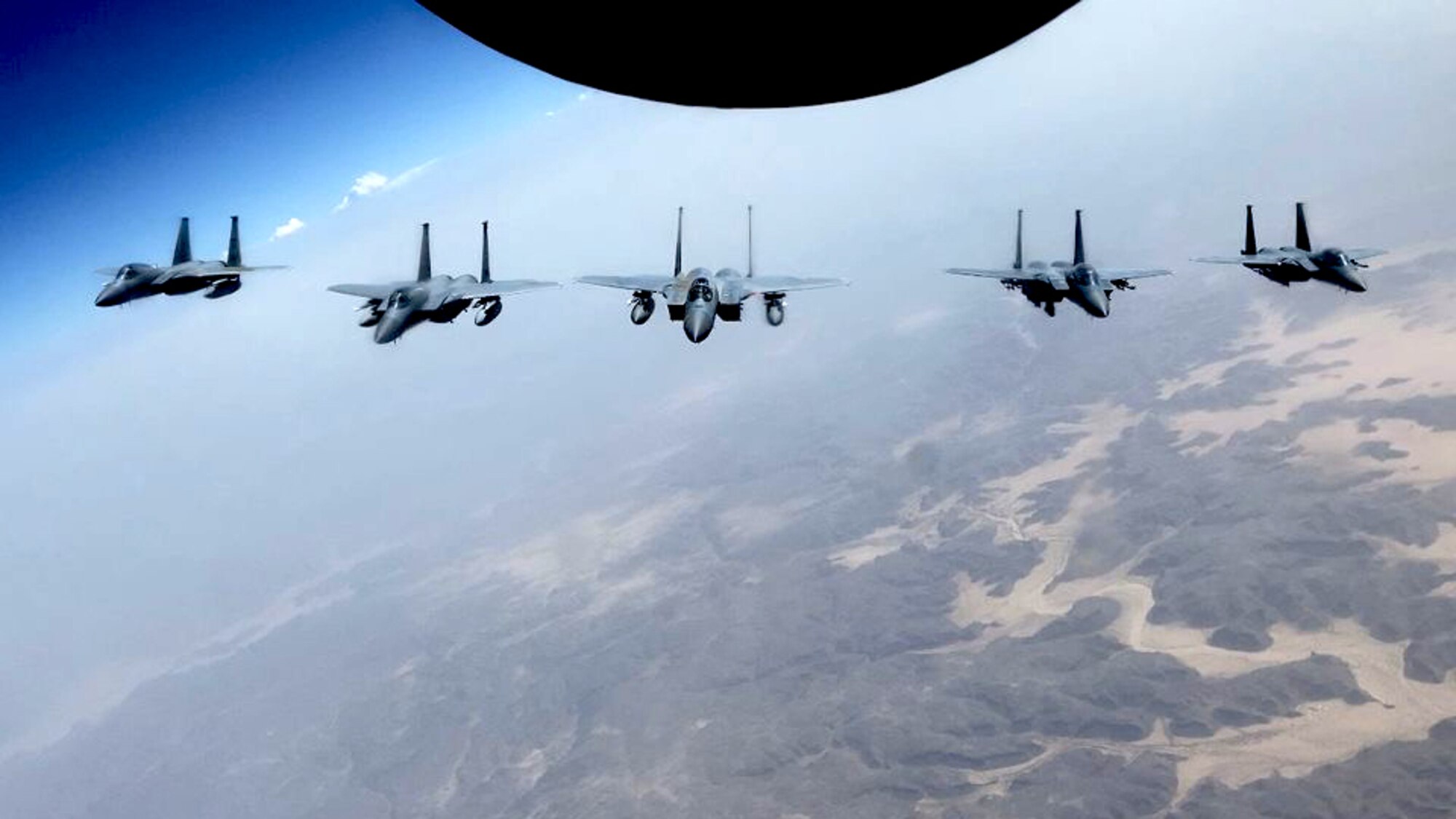 An F-15C fighter jet from the 44th Expeditionary Fighter Squadron, Prince Sultan Air Base, Kingdom of Saudi Arabia, flys in formation with two F-15SA Royal Saudi Air Force jets from the 6th Squadron, King Khalid Air Base, Kingdom of Saudi Arabia and a KC-135 Stratotanker from Al Udeid, Qutar, during an integrated sortie flight in the Kingdom of Saudi Araibia, June 25, 2020. The integrated sorties allow U.S. and RSAF pilots to famiiliaraize themselves with communications and mission planning procedures. It also allows them to maintain readiness for longer mission capabilities.