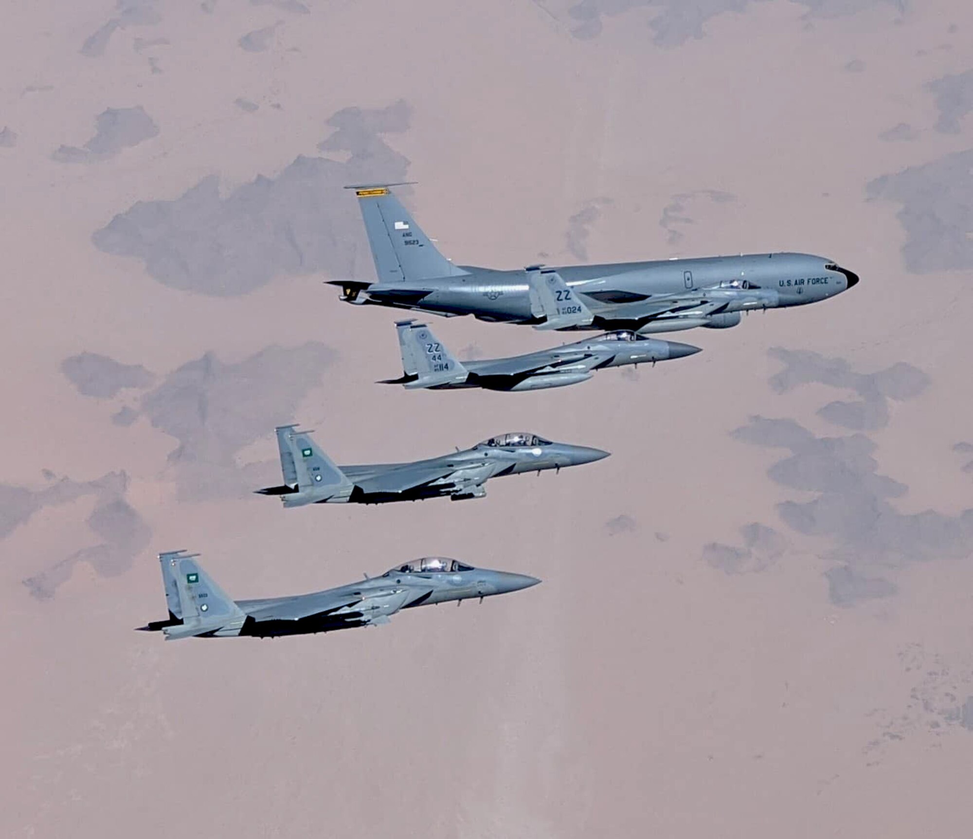 An F-15C fighter jet from the 44th Expeditionary Fighter Squadron, Prince Sultan Air Base, Kingdom of Saudi Arabia, flys in formation with two F-15SA Royal Saudi Air Force jets from the 6th Squadron, King Khalid Air Base, Kingdom of Saudi Arabia and a KC-135 Stratotanker from Al Udeid, Qutar, during an integrated sortie flight in the Kingdom of Saudi Araibia, June 25, 2020. The integrated sorties allow U.S. and RSAF pilots to famiiliaraize themselves with communications and mission planning procedures. It also allows them to maintain readiness for longer mission capabilities.