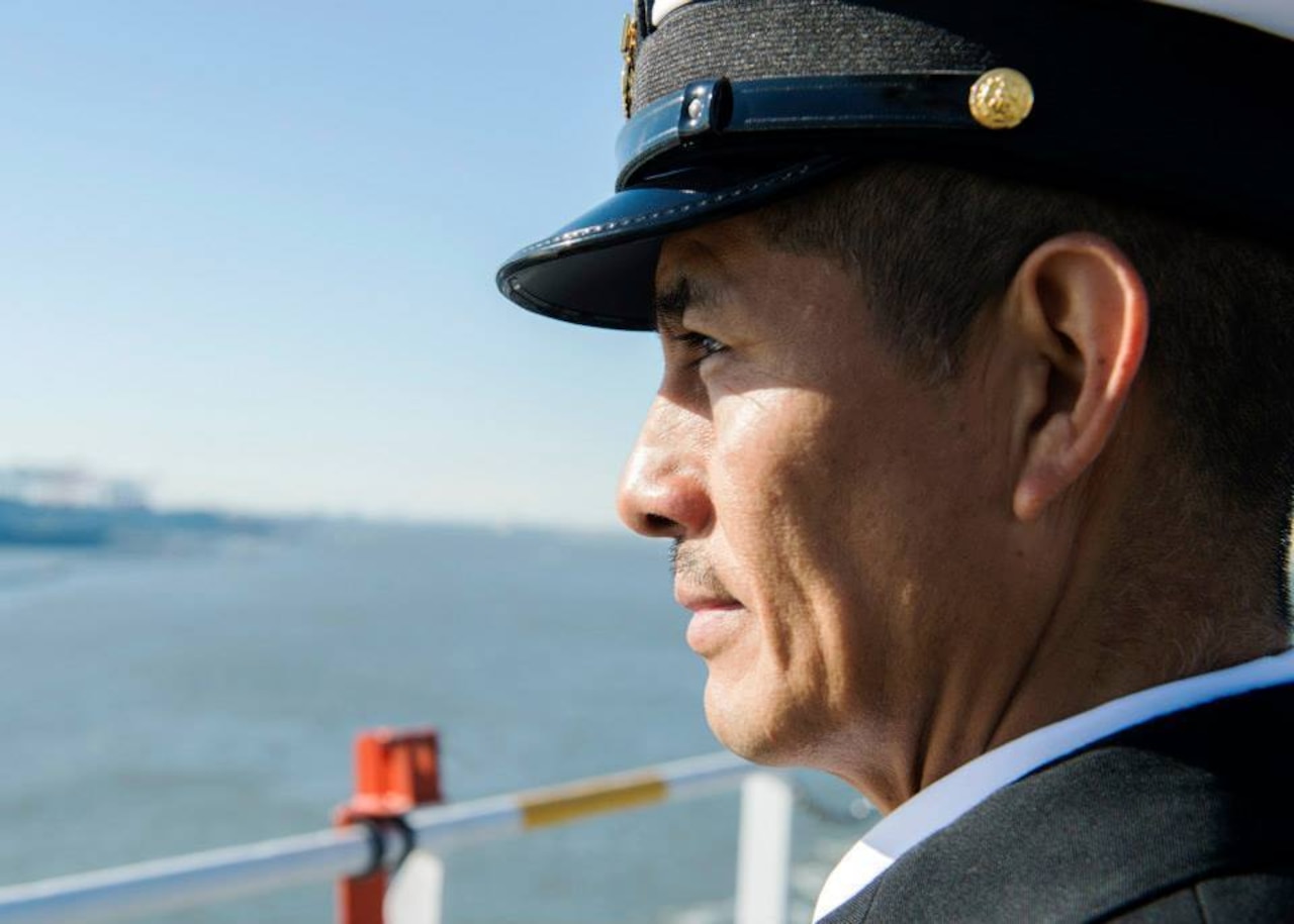 A man wearing a cap looks into the distance.