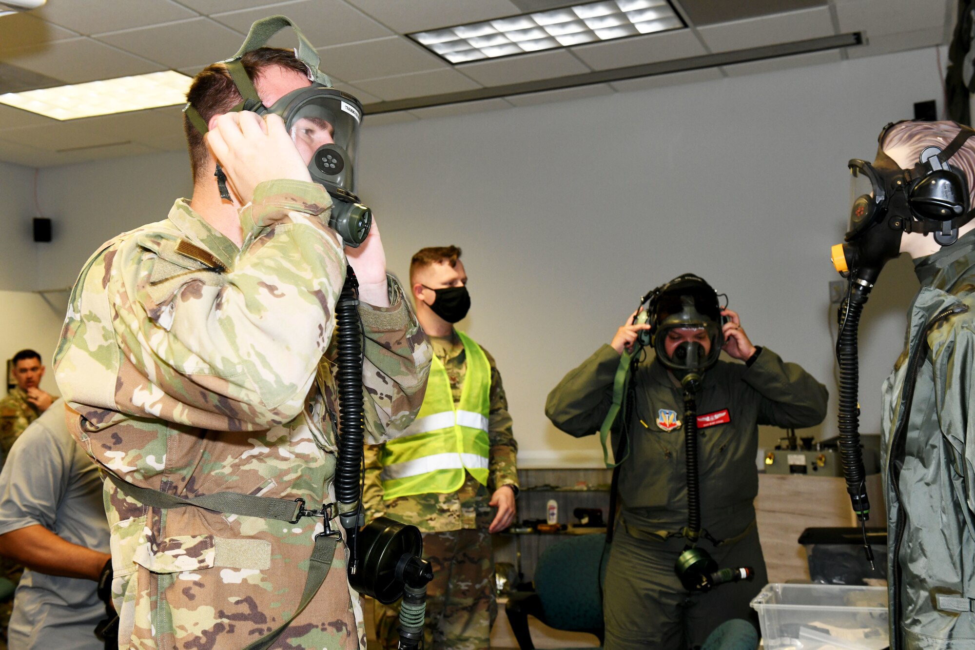 Photo shows two individuals putting on masks.