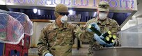 Alaska Army National Guard Soldiers Sgt. Kekoa Maclovesramirez and Staff Sgt. Edward Jones, assigned to the AKARNG Recruiting and Retention Battalion, slice cucumbers for pre-packed lunches in the kitchen at Bean’s Cafe in Anchorage, Alaska, Apr. 8, 2020. This food will be distributed to thousands of local Alaskans sheltering at Sullivan and Boeke arenas as well as the Alaska After School Lunch program. (U.S. Army National Guard photo by Sgt. Seth LaCount/Released)