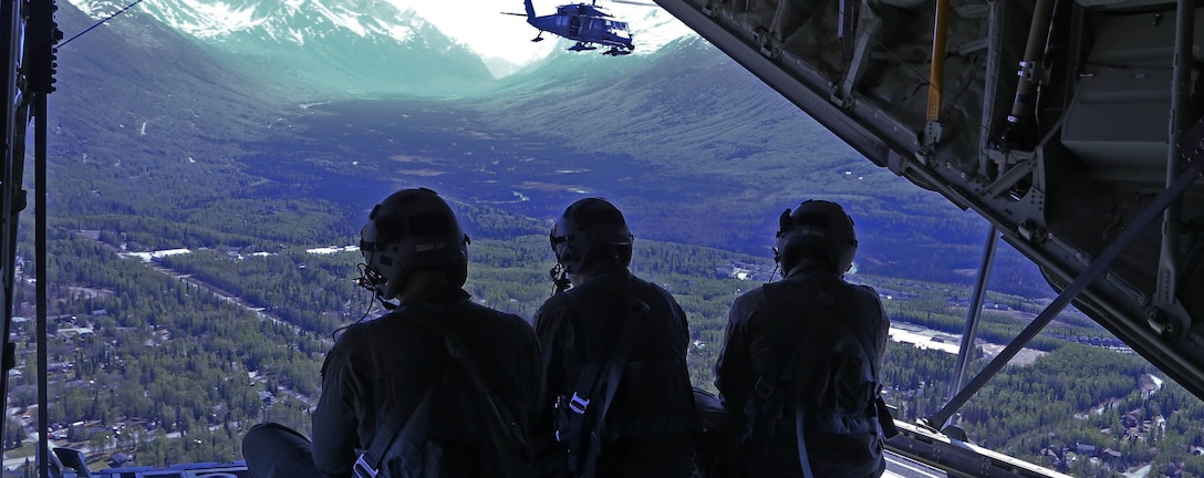 Alaska Air National Guard Loadmasters aboard a HC-130J Combat King II observe an HH-60 Pave Hawk as it prepares for an aerial refueling. The 176th Wing conducted the first of the flyovers for Alaska. The Salute to Alaska flyovers were an approved training mission and part of the Air Force Salutes initiative designed to show appreciation to the heroes around the world battling the pandemic, and to lift morale in communities across America. (U.S. Navy photo by Mass Communication Specialist 3rd Class Victoria Granado/Released)