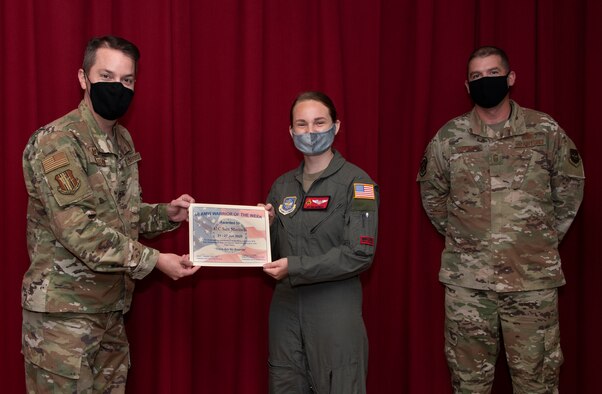 U.S. Air Force Col. Jeffrey Nelson, left, 60th Air Mobility Wing commander, and Chief Master Sgt. Stephen Scofield, right, 60th Maintenance Squadron squadron superintendent, recognize Airman 1st Class Sara Marinelli, 21st Airlift Squadron loadmaster, as the Warrior of the Week, June 23, 2020, at Travis Air Force Base, California. The program recognizes outstanding Airmen who have made significant contributions to their unit. (U.S. Air Force photo by Heide Couch)