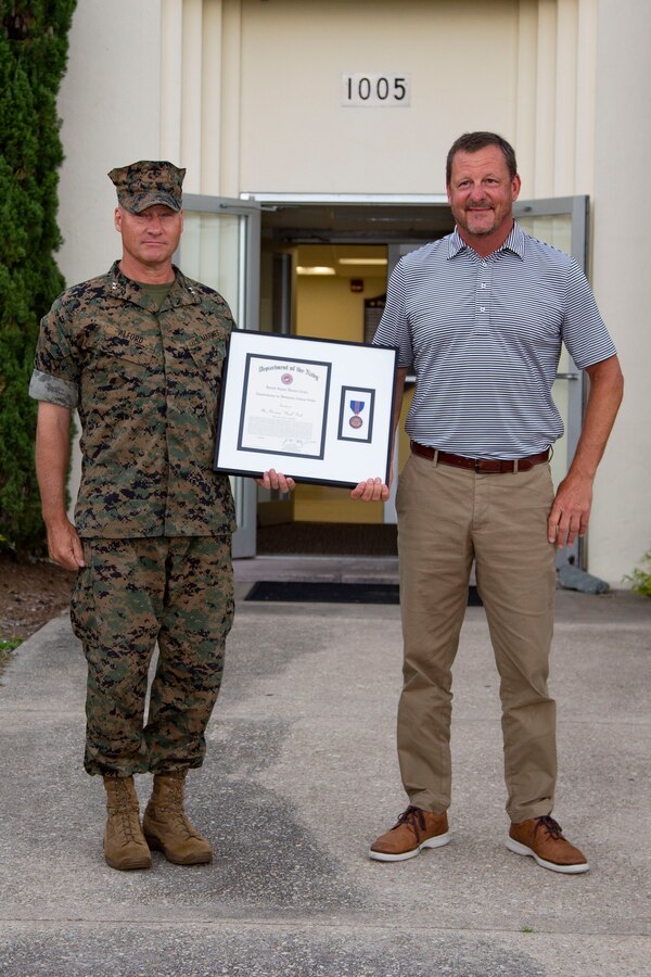 Neal Paul, right, deputy public works officer, Public Works Division, Marine Corps Installations East-Marine Corps Base Camp Lejeune, receives the Department of the Navy Commendation for Meritorious Civilian Service from Maj. Gen. Julian D. Alford, left, commanding general, Marine Corps Installations East-Marine Corps Base Camp Lejeune, at the Public Works Office on Camp Lejeune, North Carolina, June 30, 2020. Paul received the award for his efforts in coordinating a multibillion dollar restoration and construction program in the wake of Hurricane Florence. (U.S. Marine Corps photo by Lance Cpl. Ginnie Lee)