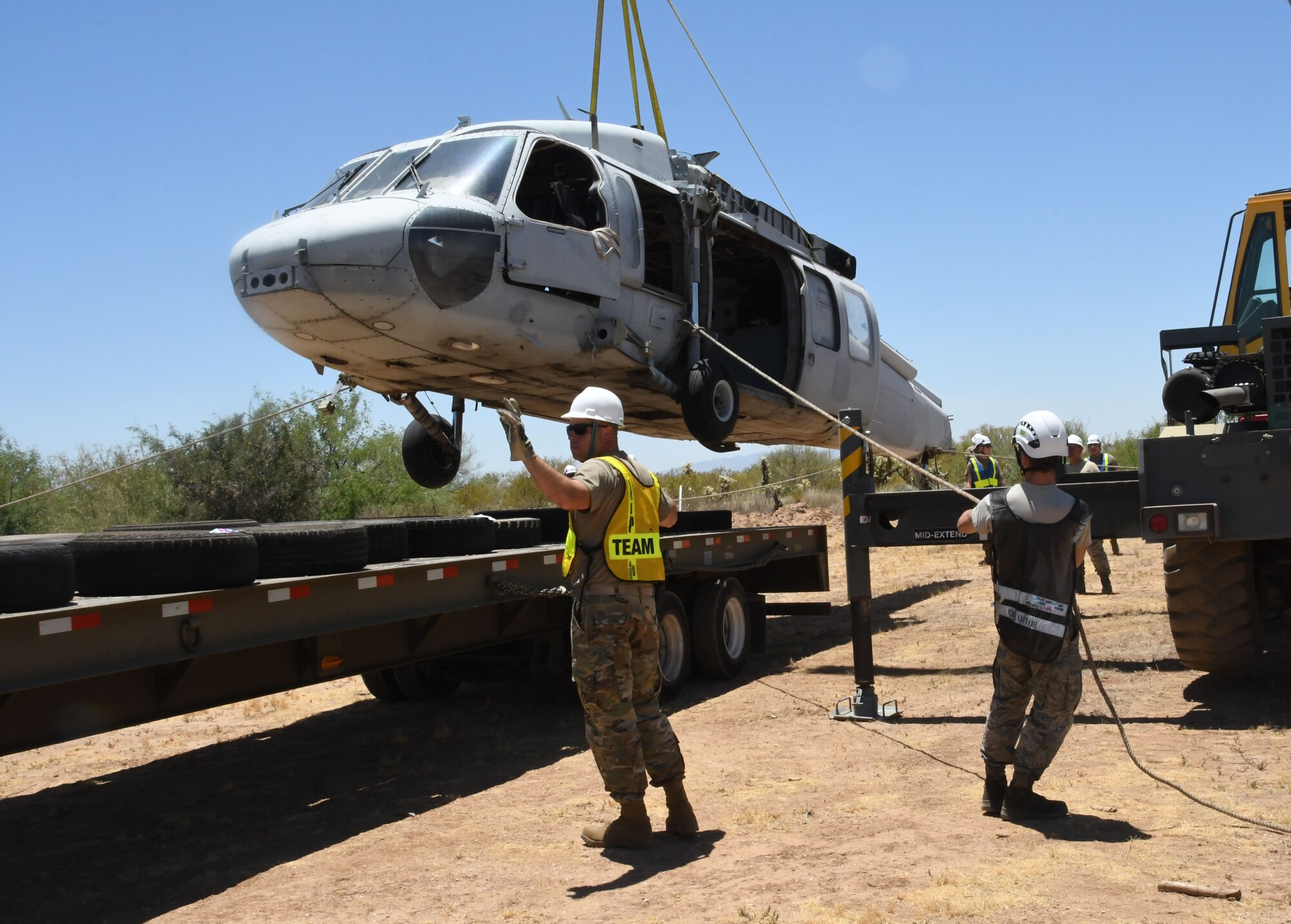 An Airman guides a helicopter onto a truck.