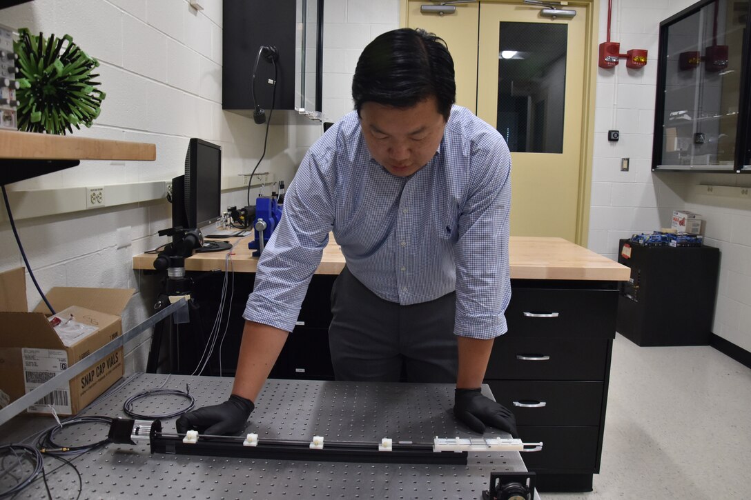 AFRL scientist, Dr. Vincent Chen, demonstrates the experimental setup used to trigger shape change in soft, magnetically responsive elastomers. (U.S. Air Force photo/Spencer Deer)