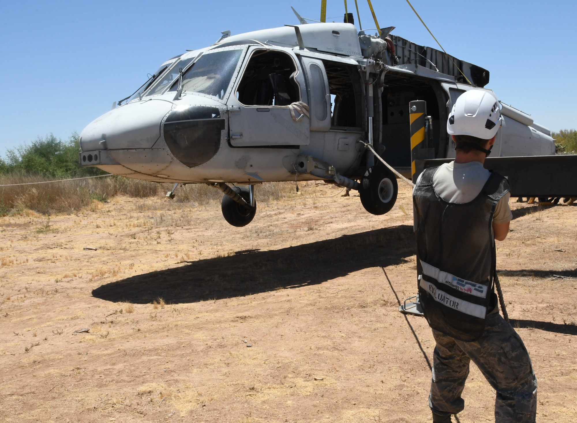 An Airman guides a helicopter onto the ground.