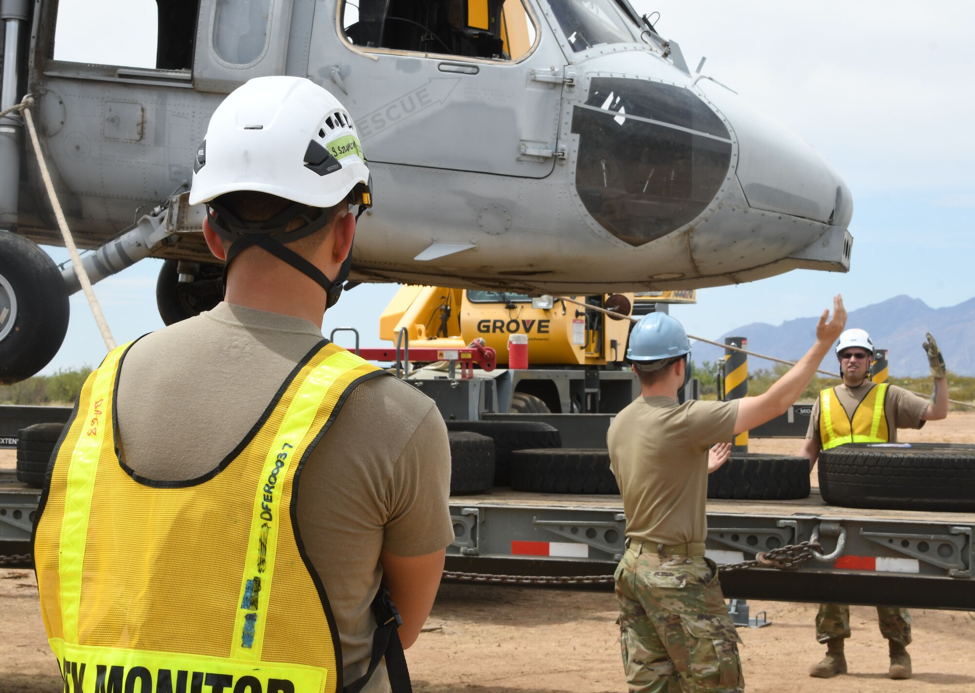 Airman guide a helicopter on a truck.