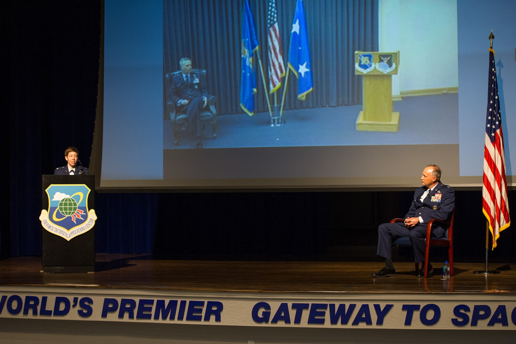 Col. Katharine Barber (left) delivers her first remarks to the men and women of the Air Force Technical Applications Center, Patrick AFB, Fla., after taking command of the center from outgoing commander Col. Chad Hartman (right) June 30, 2020.  Seen on screen is presiding officer Lt. Gen. Timothy Haugh, commander of 16th Air Force, who streamed via video teleconference from Lackland AFB, Texas. (U.S. Air Force photo by Amanda Ryrholm)