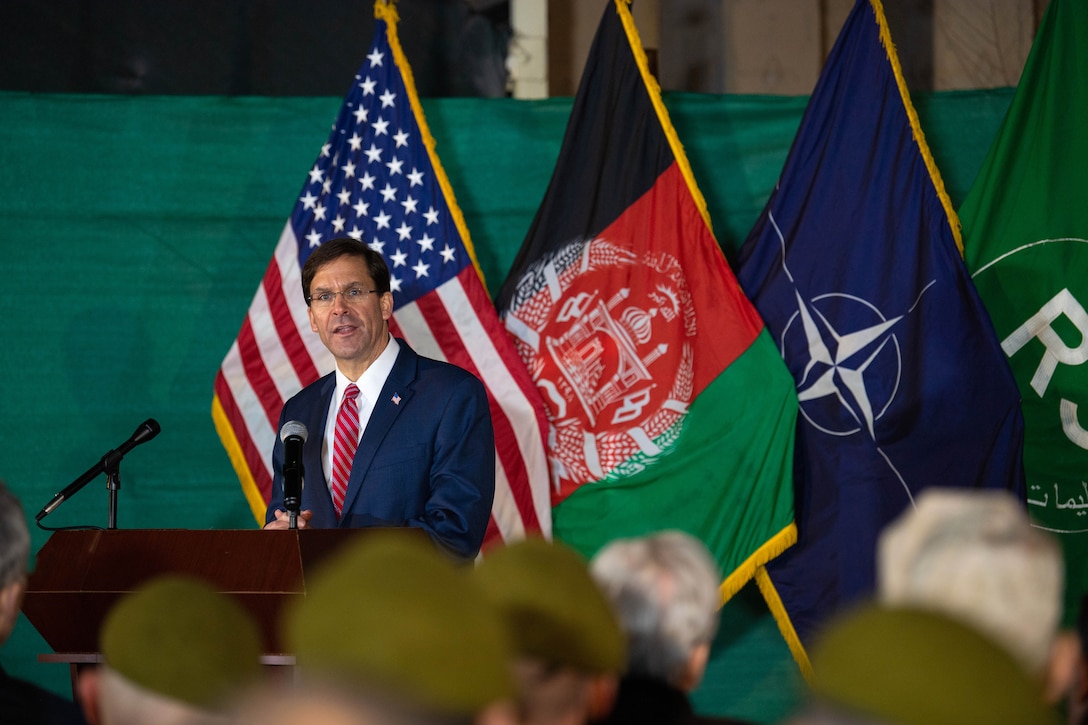 Defense Secretary Dr. Mark T. Esper speaks at a lectern with U.S., Afghan and NATO flags behind him.