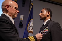 U.S. Navy Lt. Robert Daniels is presented with a Navy meritorious service medal by U.S. Navy Capt. Bryan Schumacher during his retirement ceremony at Joint Task Force Civil Support (JTF-CS) headquarters.