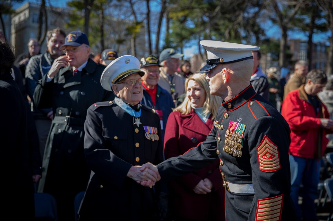 The 19th Sergeant Major of the Marine Corps, Sgt. Maj. Troy E. Black greets World War II veteran, Hershal “Woody” Williams, who was awarded the Medal of Honor for his actions on Iwo Jima at a wreath laying ceremony recognizing the 75th anniversary of the battle of Iwo Jima at the Marine Corps War Memorial in Arlington, V.A., Feb. 27, 2020. The Marine Corps hosted the ceremony to honor the veterans of World War II with speeches by the Commandant of the Marine Corps and the Sergeant Major of the Marine Corps. The warrior spirit demonstrated by Marines and sailors of yesterday fuel the tradition of warfighters engaging in today’s battlespace. (U.S. Marine Corps photo by Sgt. Victoria Ross)