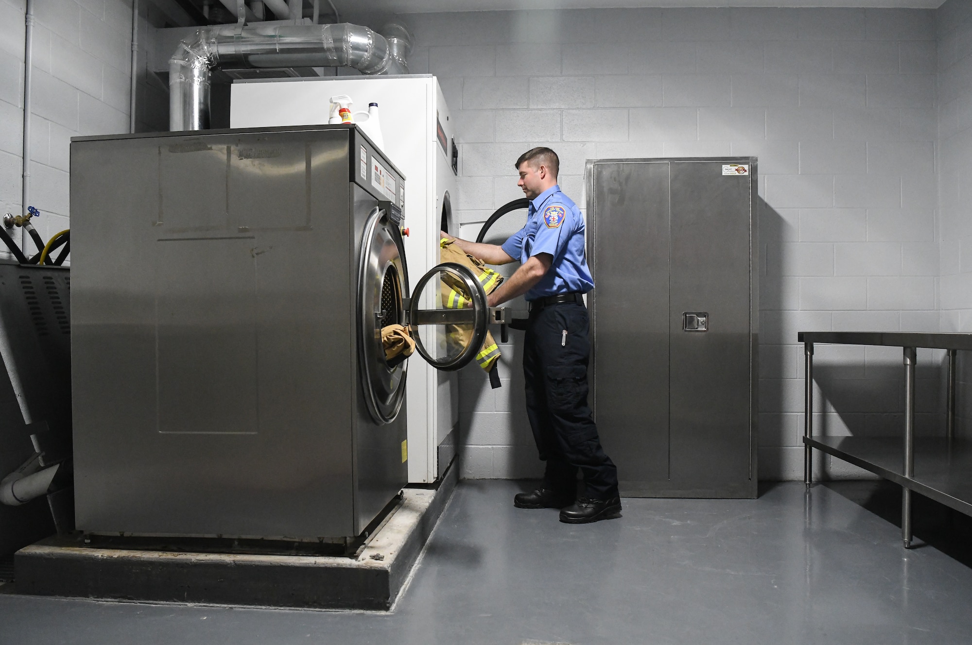 Josh Seymour, a firefighter with Arnold Air Force Base Fire and Emergency Services, loads turnout gear into a large dryer, Jan. 21, 2020, in the FES station at Arnold AFB. A recently completed addition provides a space for FES personnel to properly clean their personal protective equipment. (U.S. Air Force photo by Jill Pickett)
