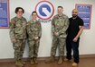 The 1st Theater Sustainment Command (TSC) surgeon cell gathers for a photo outside their office in the 1st TSC headquarters building, Feb. 20, 2020. Left to right: Lt. Col. Elizabeth Duque, command surgeon, 1st TSC, Maj. Tosha Nichols, environmental science engineering officer (ESEO), Master Sgt. David Phillips, surgeon noncommissioned officer-in-charge (NCOIC), and Adrian Cano, medical readiness technician. (Capt. Keith Sanders, medical operations officer, is not pictured). (U.S. Army photo by Wendy Arevalo)