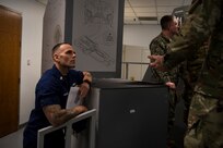 Senior Chief Petty Officer Kody Fraughton, Sector Charleston command senior chief, listens to a briefing of a C-17 Globemaster III simulator at Joint Base Charleston, S.C., Feb. 27, 2020.