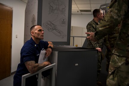 Senior Chief Petty Officer Kody Fraughton, Sector Charleston command senior chief, listens to a briefing of a C-17 Globemaster III simulator at Joint Base Charleston, S.C., Feb. 27, 2020.