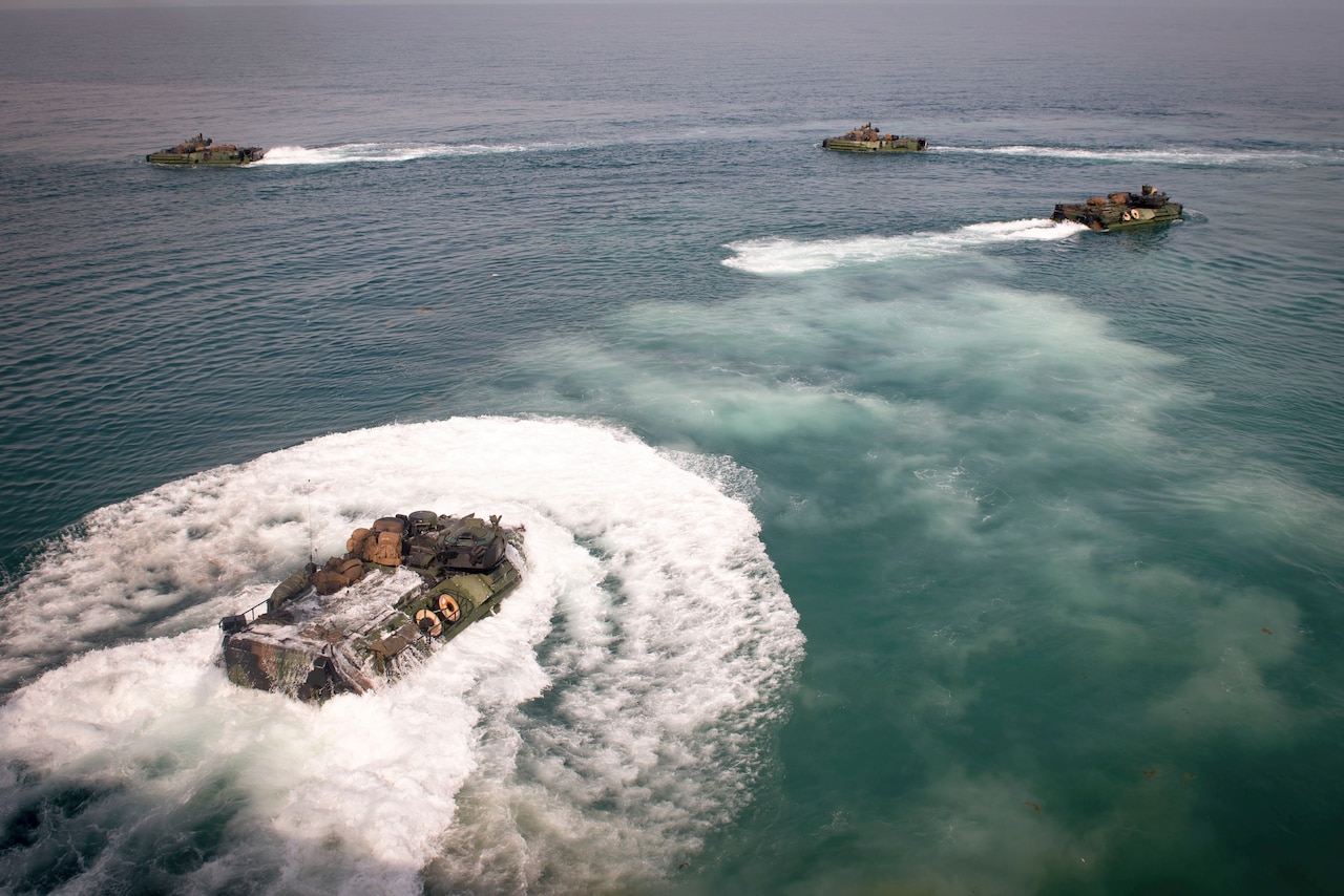 A group of boats move through waters.