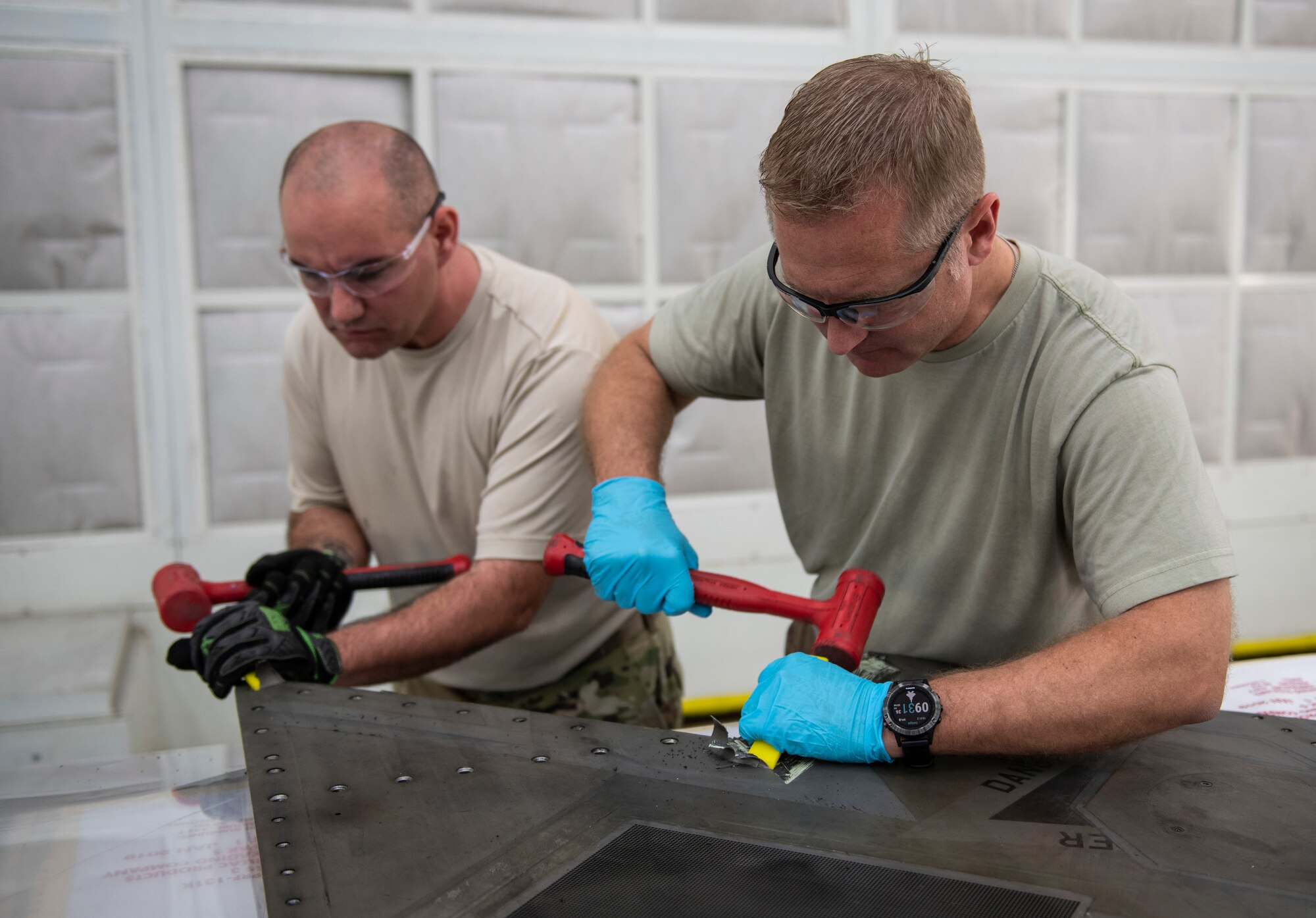 U.S. Air Force Col. Brian Laidlaw, 325th Fighter Wing commander (right), and Airman 1st Class Orin Pickering, 325th Maintenance Squadron low observable journeyman, remove the coating from an F-22 Raptor panel at Tyndall Air Force Base, Florida, Feb. 28, 2020. Laidlaw spent the morning with Pickering to learn what his job entails and even doing some of the work with him. (U.S. Air Force photo by Senior Airman Stefan Alvarez)