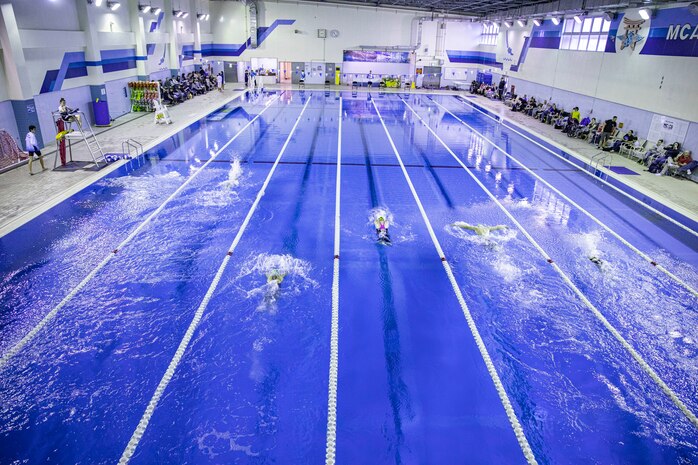 Swimmers race in a 200 meter relay at IronWorks Gym Pool, Marine Corps Air Station (MCAS) Iwakuni, Japan, February 16, 2020. The Tsunamis, the MCAS Iwakuni Schools' swim team hosted a friendly swim meet with Ocean Swim team, the local Iwakuni City swim team, in order to foster their friendship in sports. (U.S. Marine Corps photo by Lance Cpl. Triton Lai)
