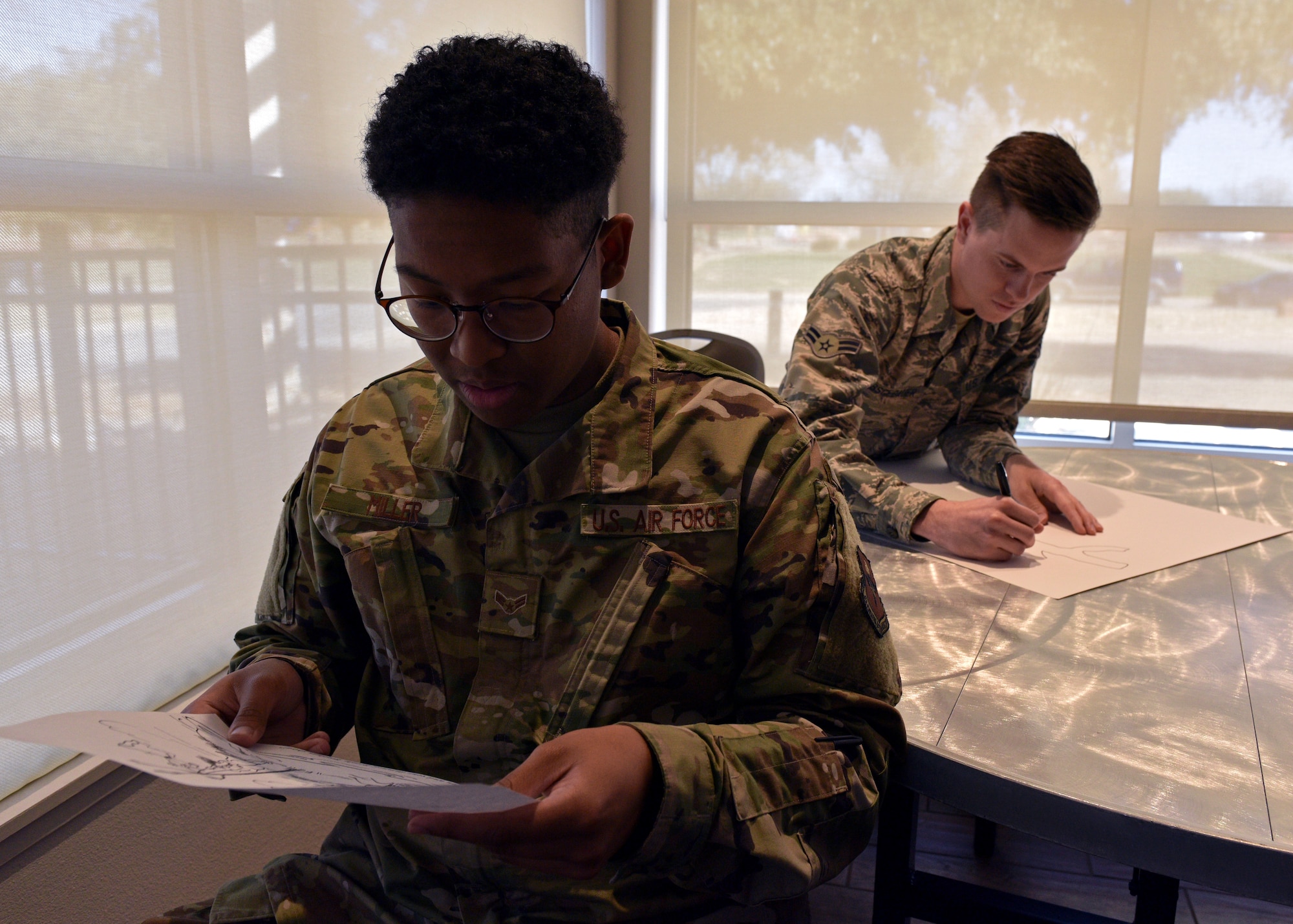 Korean linguist students from the 316th Training Squadron participate in an exercise during the 316th TRS’ Inaugural Language Fair February 28, 2020, at the event center on Goodfellow Air Force Base, Texas. One student would describe in their target language what had to be drawn, while the other, without viewing the original, did their best to recreate the image just by what the speaker said. (U.S. Air Force photo by Airman 1st Class Robyn Hunsinger)