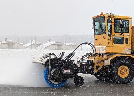 An Oshkosh Snow Broom snow removal vehicle sweeps a runway clear of snow during winter weather on Ramstein Air Base, Germany, Feb. 27, 2020.
