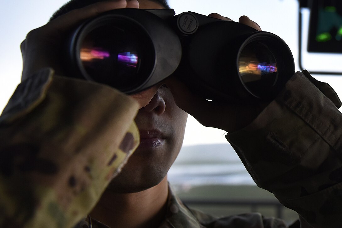 Airman 1st Class Howie Duong, 48th Operational Support Squadron air traffic controller, surveys runway activity at Royal Air Force Lakenheath, England, Feb. 25, 2020. Air traffic control Airmen are highly trained professionals able to make quick decisions, while monitoring many variables to keep bases, airspace and Airmen all over the world safe. (U.S. Air Force photo by Airman 1st Class Jessi Monte)