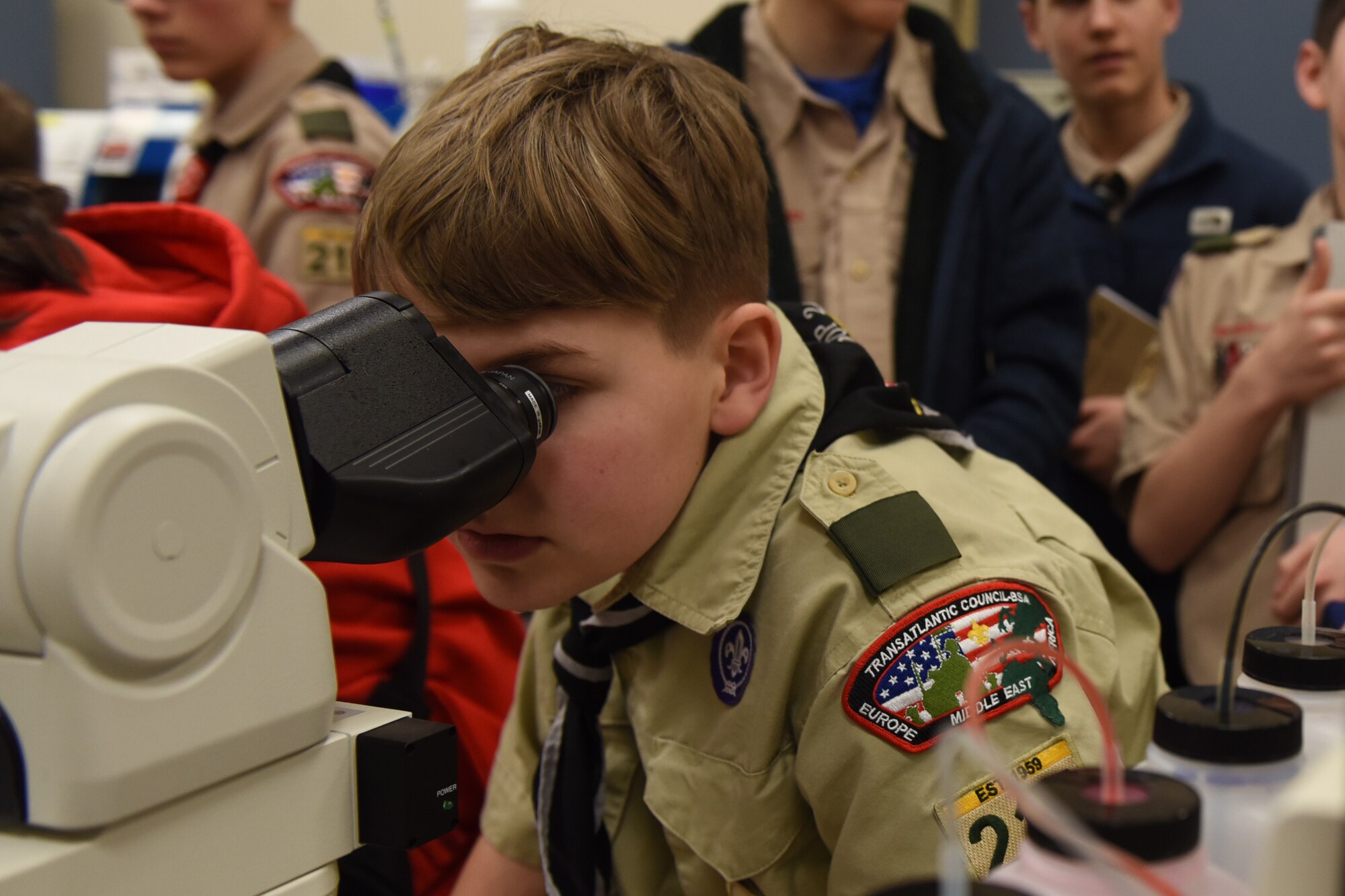 A scout assigned to Boy Scouts of America troop 215 looks at a blood sample through a microscope during a tour of the 48th Medical Group at Royal Air Force Lakenheath, England, Feb. 28, 2020. The troops got the opportunity to speak with U.S. Air Force professionals from several departments and learn about the different medical specialties. (U.S. Air Force photo by Airman 1st Class Jessi Monte)