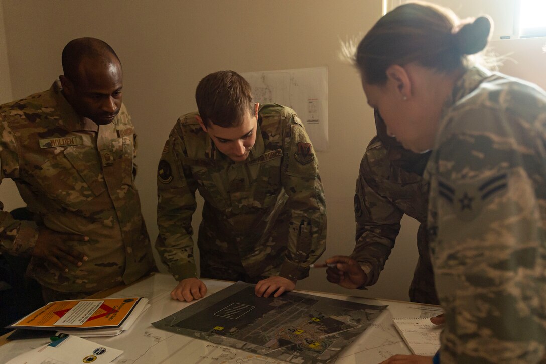 Photo of Airmen assigned to the 23d Civil Engineer Squadron pinpointing simulated damages on a map during a natural disaster response exercise.