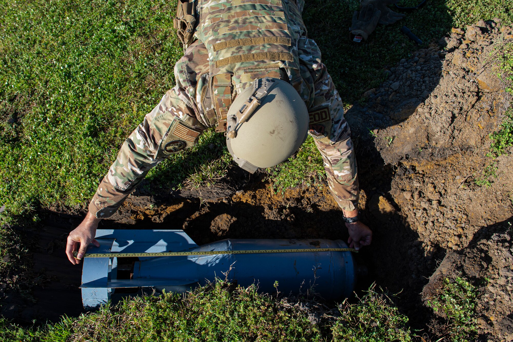 Photo of an Airman measuring a BDU-33 practice bomb during a natural disaster response exercise.