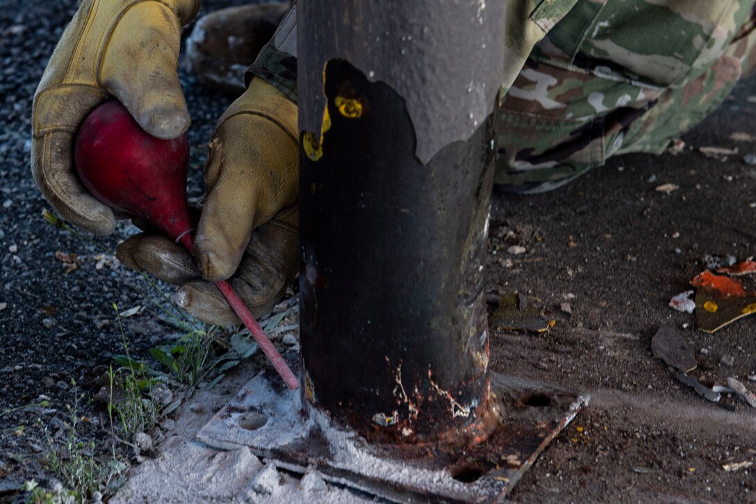 Photo of an Airman measuring a BDU-33 practice bomb during a natural disaster response exercise.