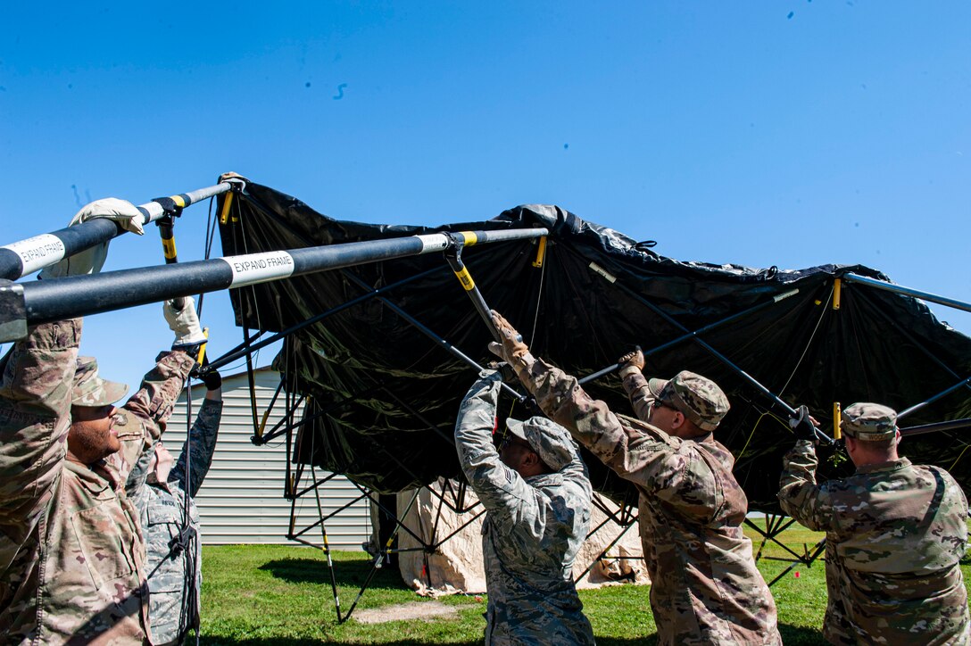 Photo of Airmen assigned to the 23d Civil Engineer Squadron setting up a tent during a natural disaster response exercise.