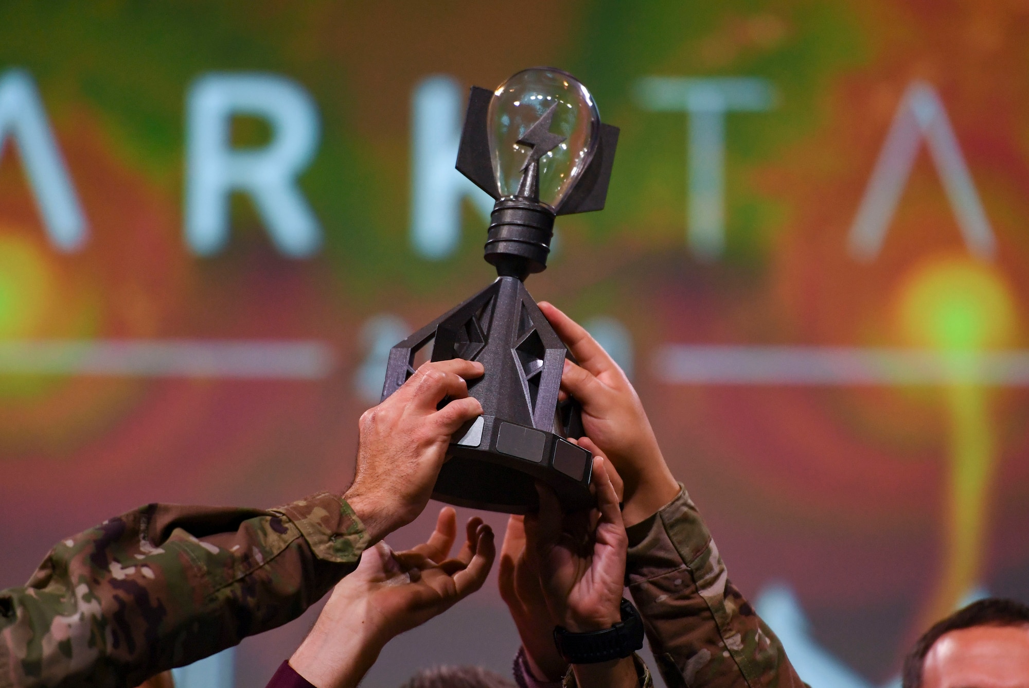 The Spark Tank trophy is held above the competition winners during the Spark Tank competition in Orlando, Florida, Feb. 28, 2020.