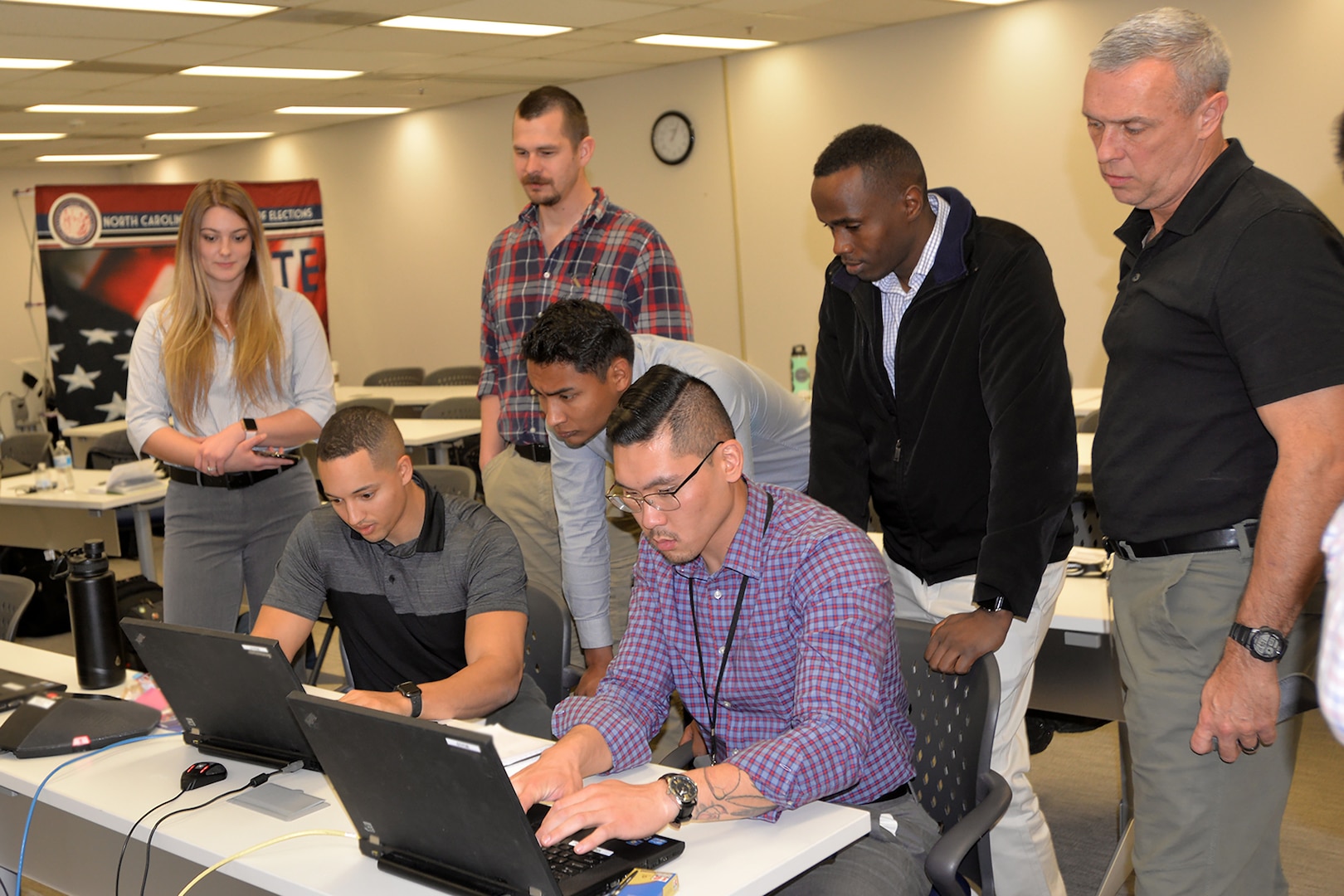 North Carolina National Guard cyber professionals, from left, Spc. Azaria Christian, Sgt. Michael Gibbs, Spc. Richard Glenn, Spc. Jose Zuniga, Spc. Mei Gerrans, 1st Lt. Joseph Muraguri and Chief Master Sgt. Randy Conner,  test equipment to protect the North Carolina electoral system from cyberattack before and during the "Super Tuesday" election March 3, 2020. They are part of the Guard's Cyber Security Response Force.