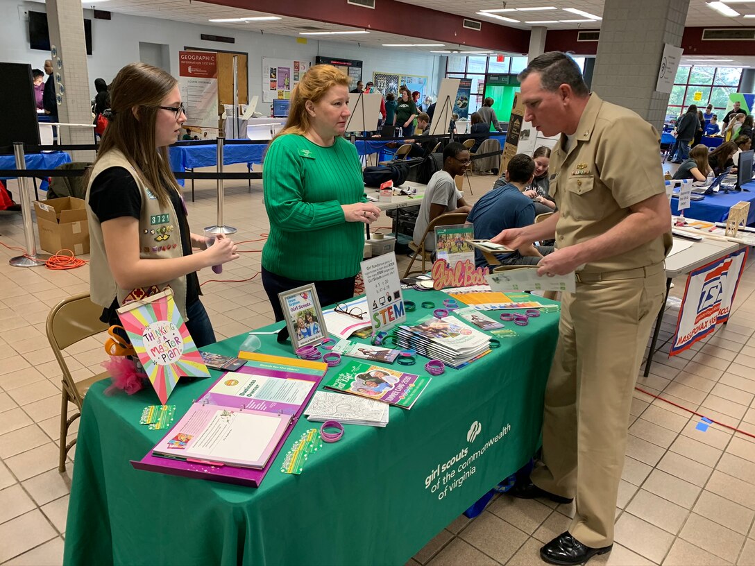 IMAGE: SPOTSYLVANIA, Va. (Feb. 29, 2020) – Capt. Casey Plew, Naval Surface Warfare Center Dahlgren Division (NSWCDD) commanding officer, talks with members of the Girl Scouts of the Commonwealth of Virginia at the annual science, technology, engineering, mathematics (STEM) Summit hosted by Chancellor High School. Plew was among the NSWCDD leaders, scientists and engineers who joined a myriad of organizations to engage students with science, technology, engineering, mathematics (STEM) demonstrations. “With new programs in outdoor adventure and STEM and the promise of dozens of new skills to learn and awards to earn, at Girl Scouts the trail is yours to blaze,” according to the organization’s website. (U.S Navy photo/Released)
