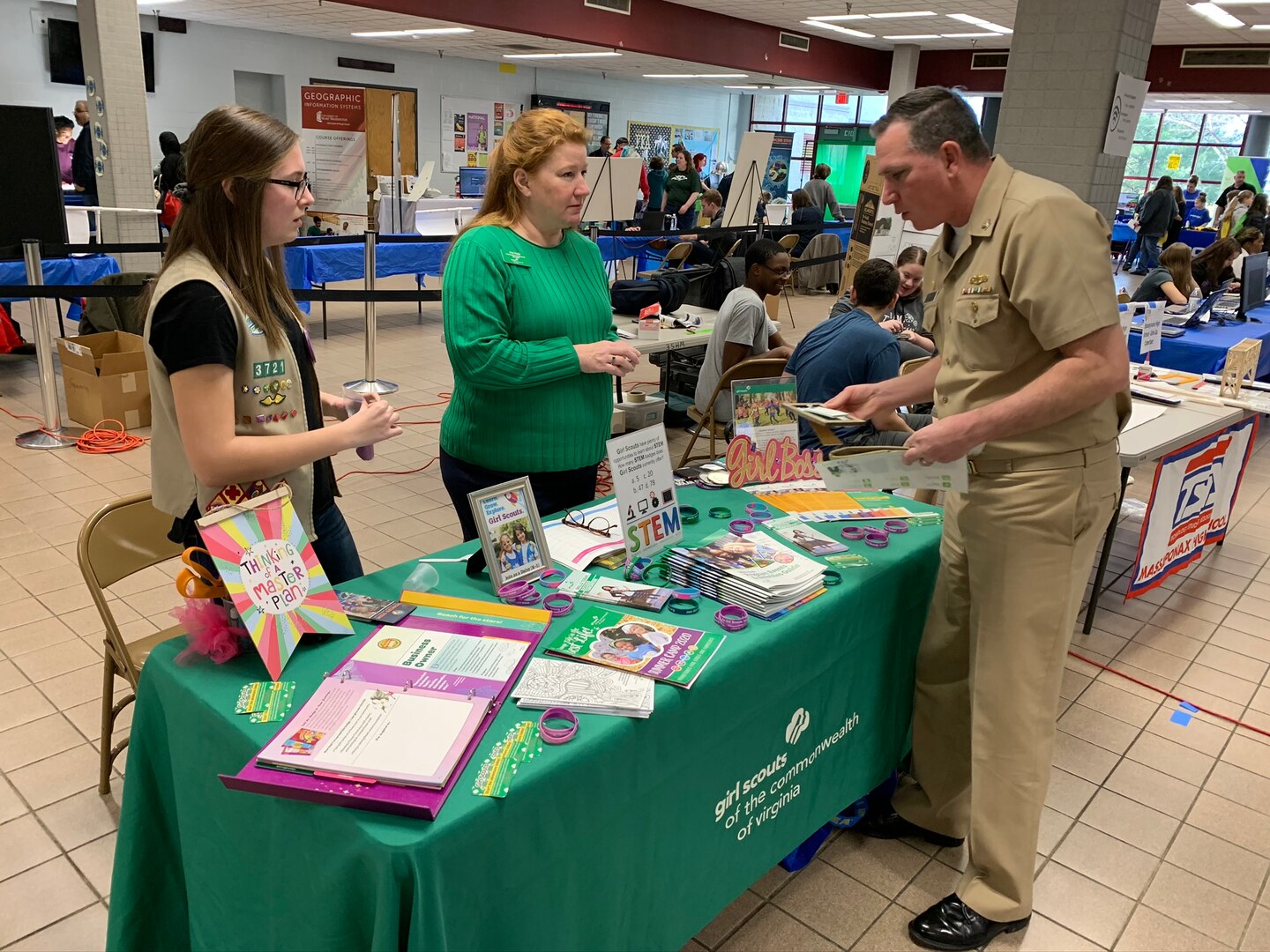 IMAGE: SPOTSYLVANIA, Va. (Feb. 29, 2020) – Capt. Casey Plew, Naval Surface Warfare Center Dahlgren Division (NSWCDD) commanding officer, talks with members of the Girl Scouts of the Commonwealth of Virginia at the annual science, technology, engineering, mathematics (STEM) Summit hosted by Chancellor High School. Plew was among the NSWCDD leaders, scientists and engineers who joined a myriad of organizations to engage students with science, technology, engineering, mathematics (STEM) demonstrations. “With new programs in outdoor adventure and STEM and the promise of dozens of new skills to learn and awards to earn, at Girl Scouts the trail is yours to blaze,” according to the organization’s website. (U.S Navy photo/Released)
