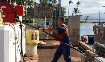 A man prepares fuel lines used to refuel small boats in Maui, Hawaii.